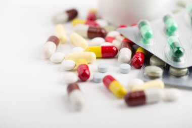 Beyaz arka plan üzerinde ilaç hapları, tabletler ve kapsüller