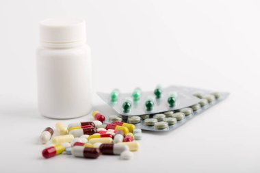 Beyaz arka plan üzerinde ilaç hapları, tabletler ve kapsüller