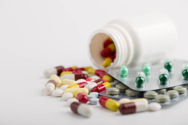 Beyaz arka plan üzerinde ilaç hapları, tabletler ve kapsüller