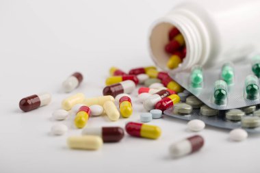 Beyaz arka plan üzerinde ilaç hapları, tabletler ve kapsüller