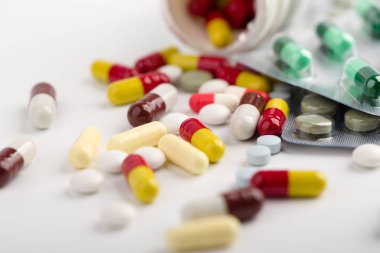 Beyaz arka plan üzerinde ilaç hapları, tabletler ve kapsüller