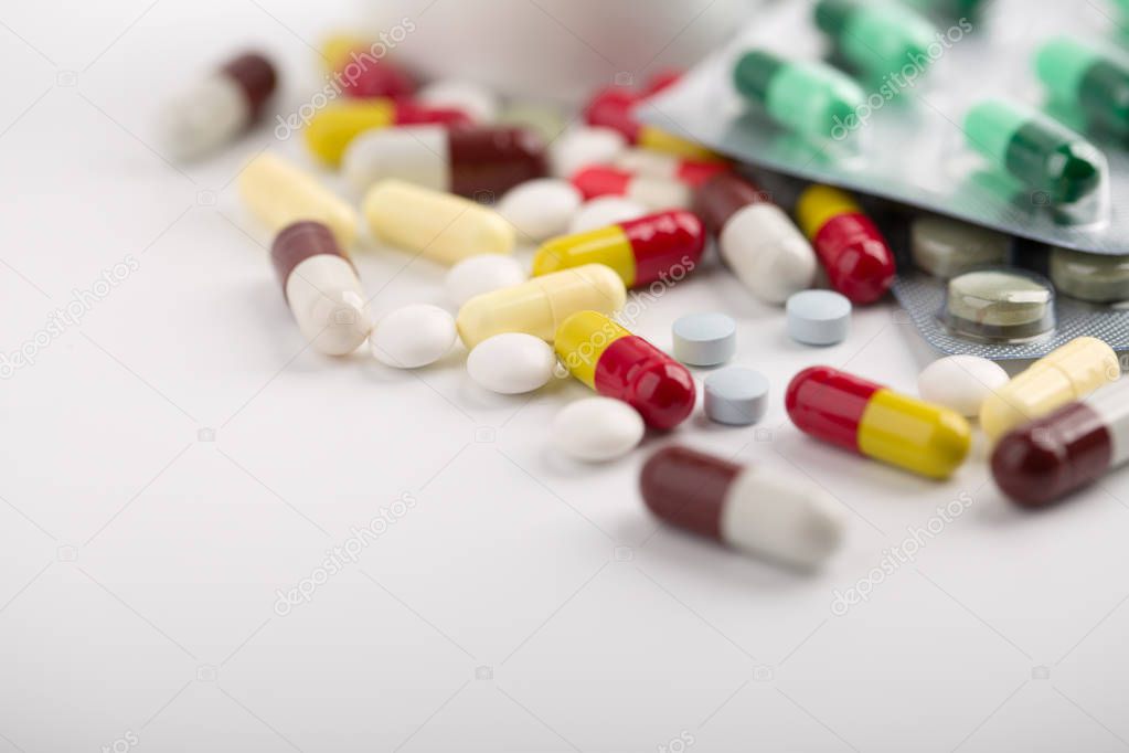 Medicine pills, tablets and capsules over white background