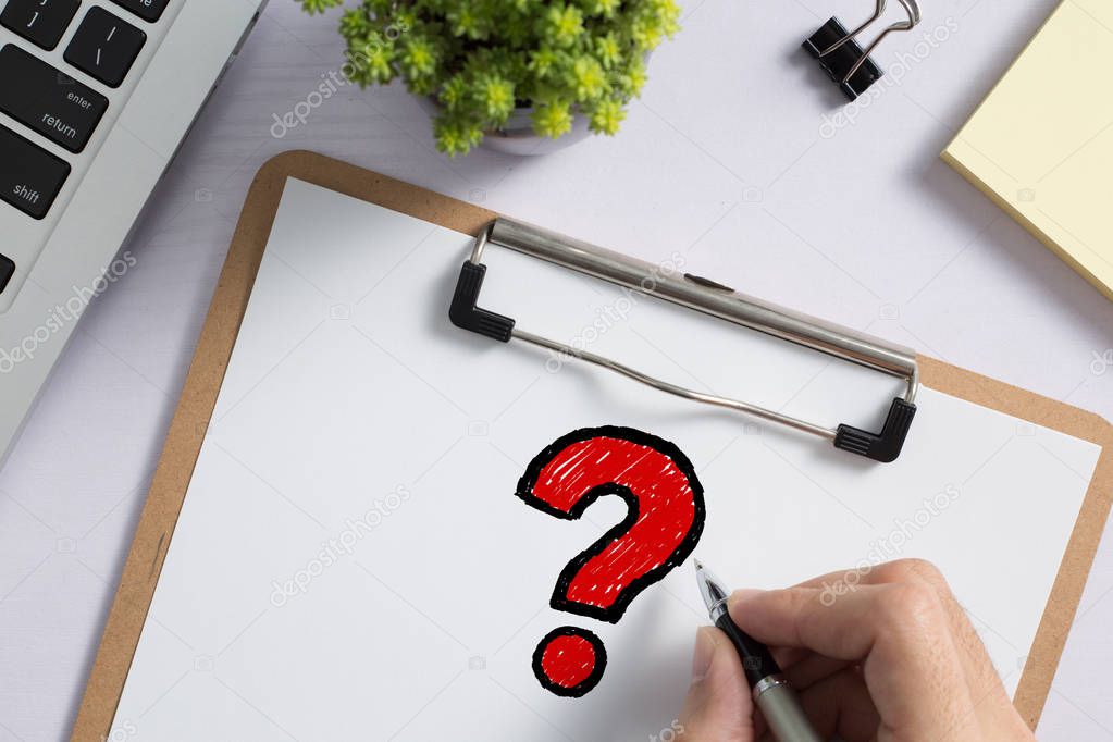 Topview of office desktop with red question mark.