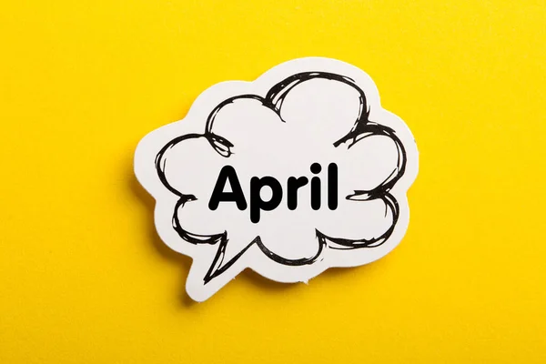 黄色の背景に隔離された4月の音声バブル — ストック写真