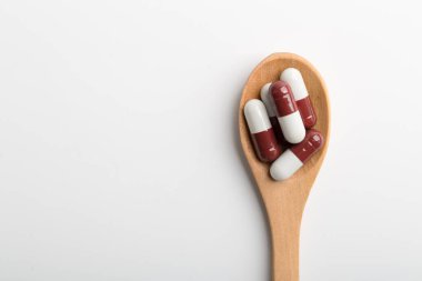 Eczane teması, beyaz arka planda ilaç içeren kaşık.