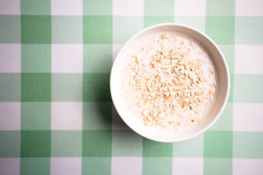 Yuvarlanmış yulaf, sağlıklı kahvaltılık gevrek gevrekleri, masada süt kasesi..