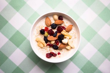Sağlıklı kahvaltı. Taze granola, yoğurt sütlü müsli ve masa arkasında fındık. Kopyalama alanı olan üst görünüm.