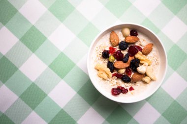Sağlıklı kahvaltı. Taze granola, yoğurt sütlü müsli ve masa arkasında fındık. Kopyalama alanı olan üst görünüm.