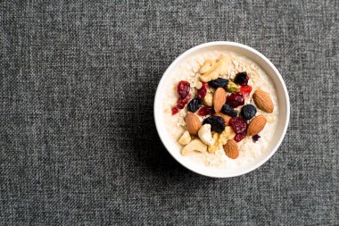 Sağlıklı kahvaltı. Taze granola, yoğurt sütlü müsli ve masa arkasında fındık. Kopyalama alanı olan üst görünüm.