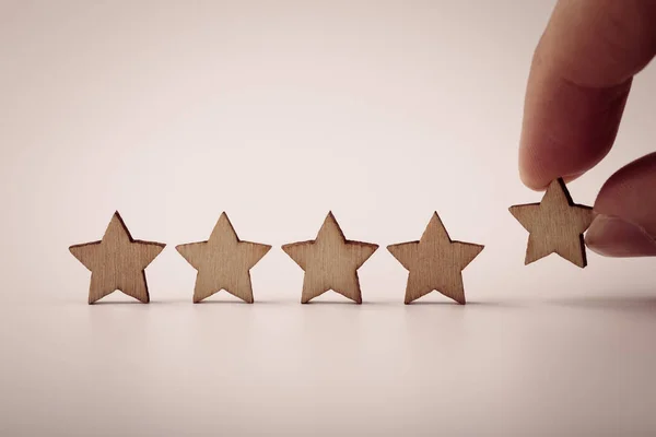 テーブルの上に木製の5つ星の形を置く手 最高のビジネスサービス評価顧客体験のコンセプト — ストック写真