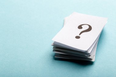 Beyaz kağıt ya da tabelaların üzerine basılmış yığın halinde soru işaretleri mavi bir arkaplanda düzenlenmiş ve kavramsal bir resimde kopya alanı ile birlikte.