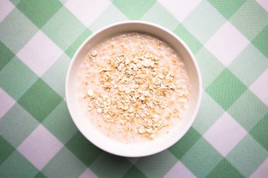 Yuvarlanmış yulaf, sağlıklı kahvaltılık gevrek gevrekleri, masada süt kasesi..