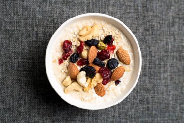 Sağlıklı kahvaltı. Taze granola, yoğurt sütlü müsli ve masa arkasında fındık. Kopyalama alanı olan üst görünüm.