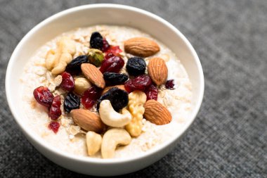 Sağlıklı kahvaltı. Taze granola, yoğurt sütlü müsli ve masa arkasında fındık. Kopyalama alanı olan üst görünüm.