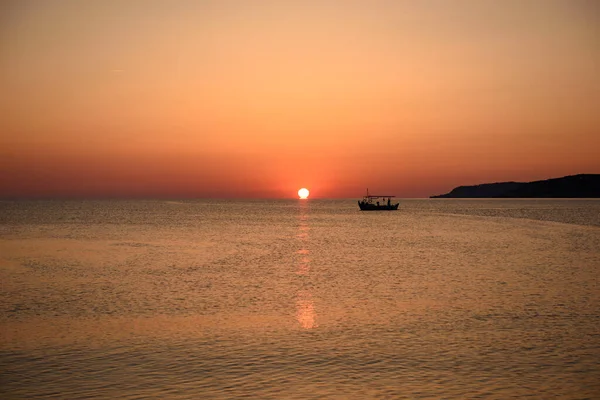 Bir balıkçı teknesi şafakta denize açılır.