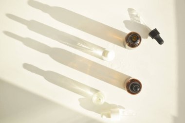 Doğal ahşap ve pastel renklerin arka planında pipetle birlikte şişelerdeki kozmetik kokulu yağlar. Doğal eko kozmetik konsepti.