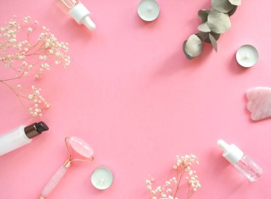 Yüzünde pembe doğal yeşim taşıyla kuvars silindirli masaj. Gouache masaj aleti, güzellik serumu yağı ile. Evde yaşlanma ve kaldırma karşıtı. Yüz masajı ve rahatlama konsepti.