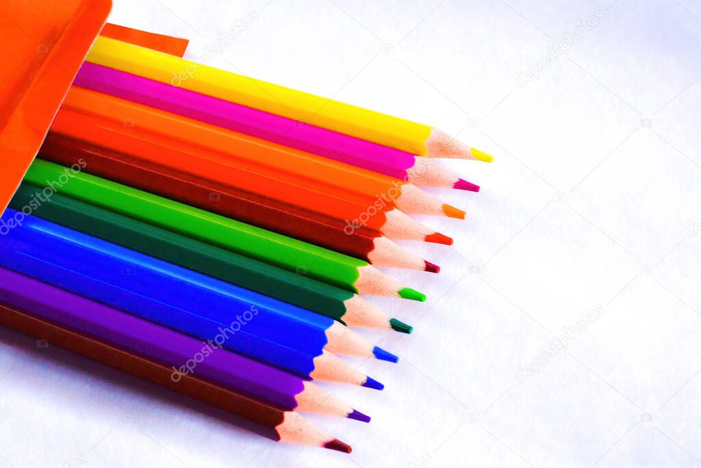 Open box of colourful pencils on white background, side border from top view. School & office concept.