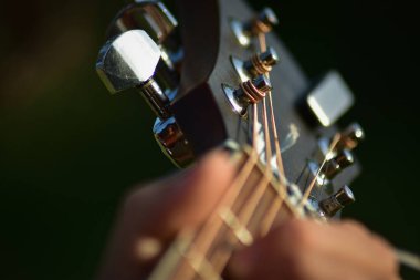 Erkek müzisyen akustik gitarla çalıyor. Eller yukarı..