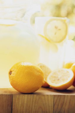 Sarı kareli masa örtüsünde taze limonata ve limonlar..