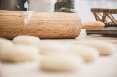 Mutfakta hamuru yuvarlıyor ve pişiriyor..