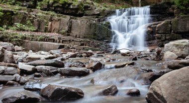Ormandaki bir dağ nehrinde şelale. Uzun pozlama.