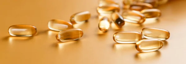 Sarı arka planda birçok Omega 3 kapsülü var. Yakın çekim, yüksek çözünürlüklü ürün. Sağlık hizmeti kavramı.