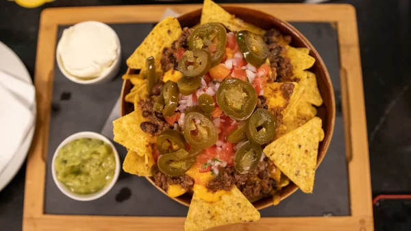 Nachos 'u et ve acı biberli, ekşi krema ve avokadoyla yakından izle.