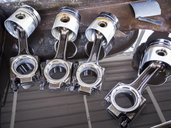 Four old pistons, Engine piston cleaning with oil