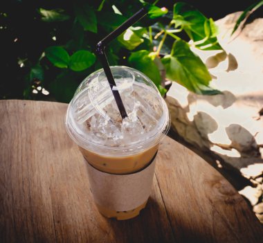 Tahta masada plastik bir bardak buzlu kahve.