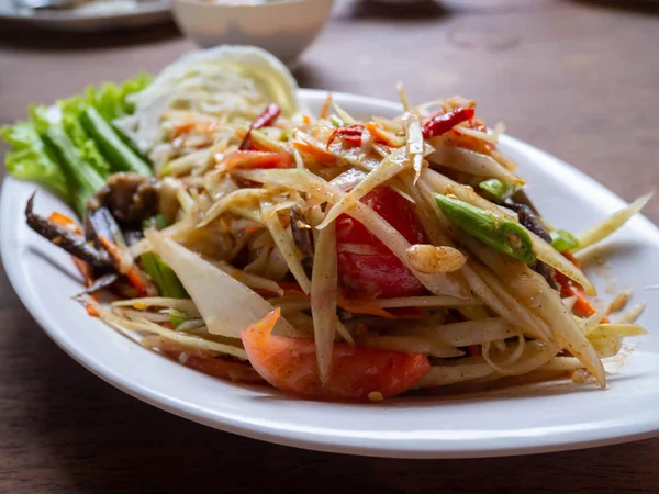 Ensalada de papaya en un plato sobre una mesa . — Foto de Stock