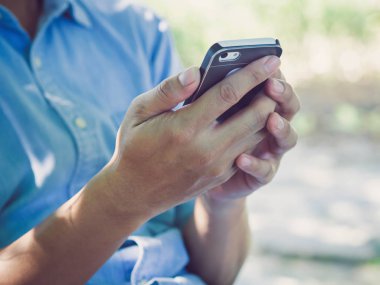 Adam akıllı telefonu tutuyor.