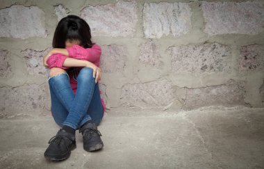 Üzgün çocuk boş bir duvarda ağlıyor..