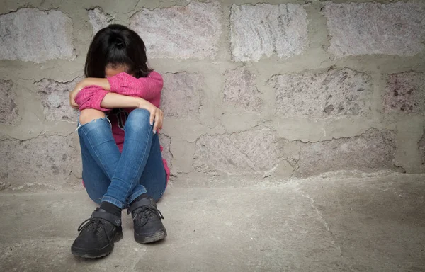 Üzgün çocuk boş bir duvarda ağlıyor..