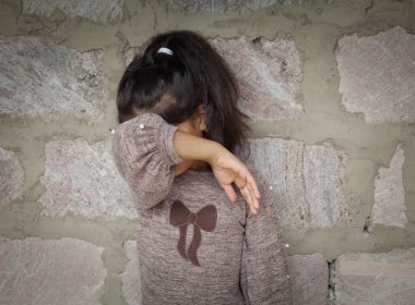 Üzgün çocuk boş bir duvarda ağlıyor..