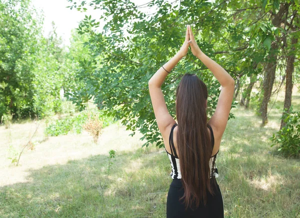 Genç kız doğada yoga yapıyor..
