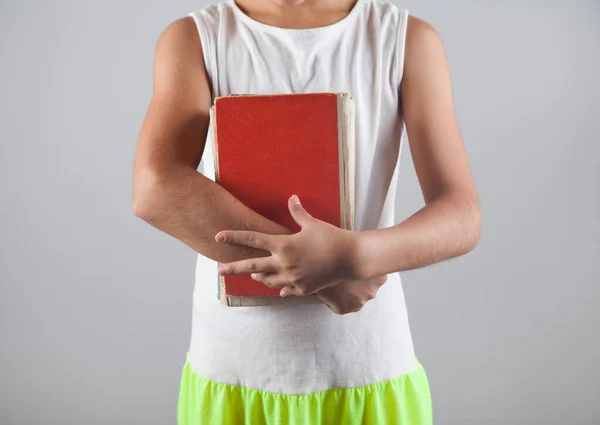 Gri arka planda kitapları olan okul çocuğu..