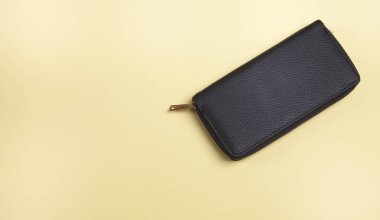 İzole edilmiş sarı arka planda kadın cüzdanı..