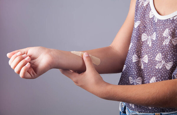 Adhesive plaster bandage on childen arm wound.