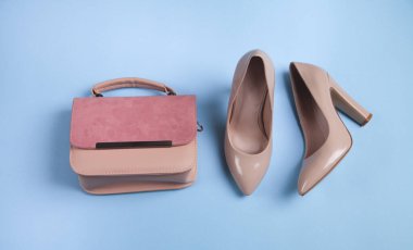 Pembe topuklu ayakkabılar ve mavi arka planda çanta..