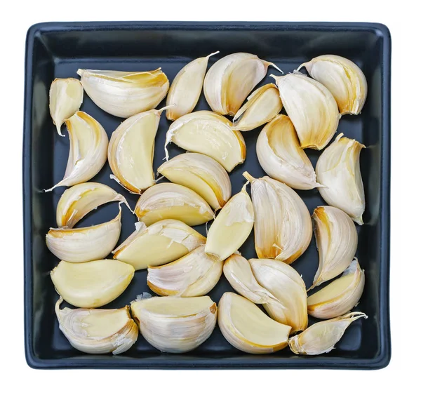 Syrový česnek a stroužky česneku na balck pokrm na bílém — Stock fotografie
