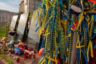 Kiev, Ukraine - on July 13, 2018: Tapes in color national flag of the participants of revolution of 2014 tied by citizens in a monument on Institutskaya Street on the place of death clipart
