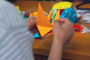 Ellerini bir adamın bir renkli origami kağıt oluşturma. Yaratıcılık