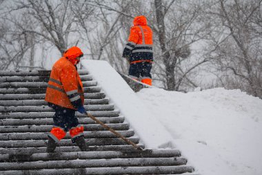 Kiev, Ukrayna - 18 Ocak 2018: Şiddetli kar yağışı karda Turuncu yelek kamu hizmetleri işçiler temiz