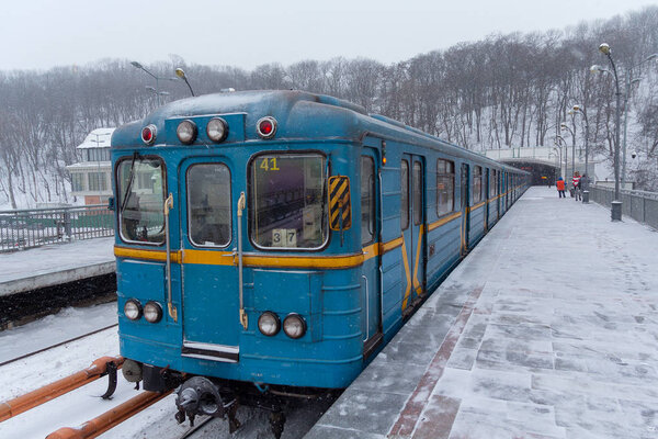 Kiev, Ukraine - March 02, 2018: Metro train on the bridge with a strong snowfall