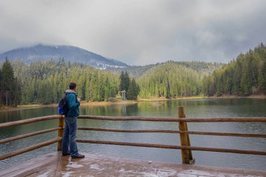 Turist ile güzel bir göle yakın sırt çantası. Seyahatler