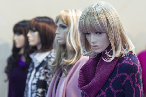 Realistic female mannequins stand in a row in the store. Sales