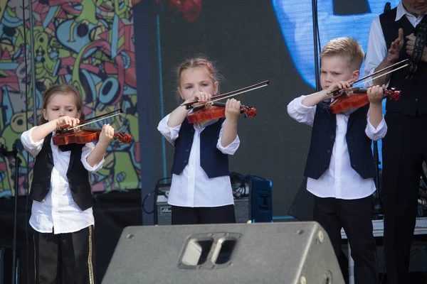 Kiev, Ucrania - 19 de mayo de 2019: Niños tocando violines en el escenario del festival de música Kleizmer en la plaza Kontraktova — Foto de Stock