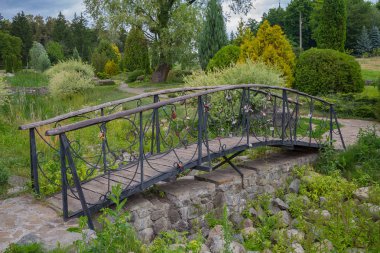Güzel metal köprü güneş tarafından kutsanan bir parkta sahte. Aşıklar Köprüsü