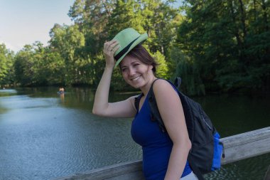 Güzel kadın bir şapka ve bir sırt çantası bridge Park. İnsanlar